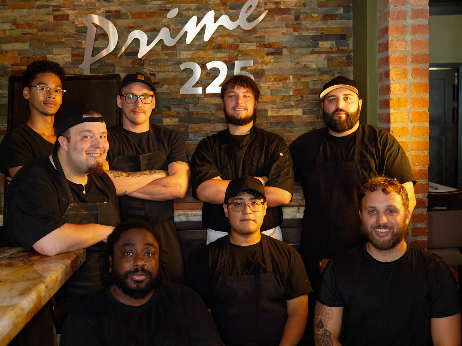 The Prime 225 kitchen crew under the sign