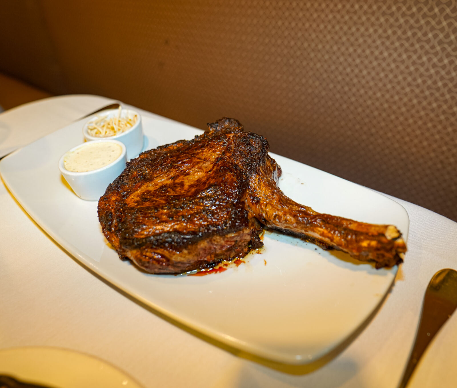 A tomahawk cut resting on the plate at Prime 225